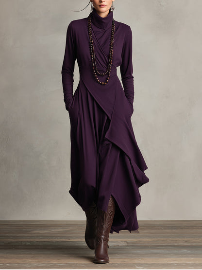 Person wearing a long, dark purple maxi dress multiple layers.