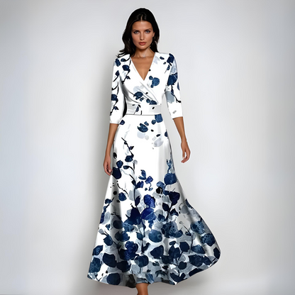 Woman wearing a white dress with blue floral pattern on a gray background