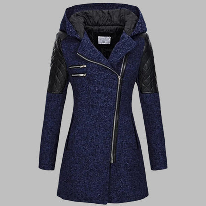 Blauwe dames winterjas met capuchon, asymmetrische rits en gewatteerde zwarte schouderstukken. Stijlvolle en warme jas voor koude dagen.