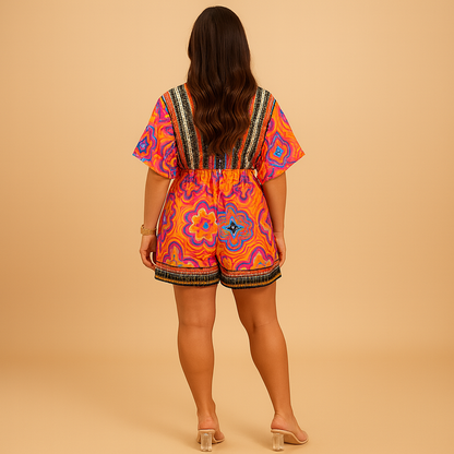 Woman wearing an orange boho summer jumpsuit with wide legs and batwing sleeves, perfect for beach days and casual summer outings.